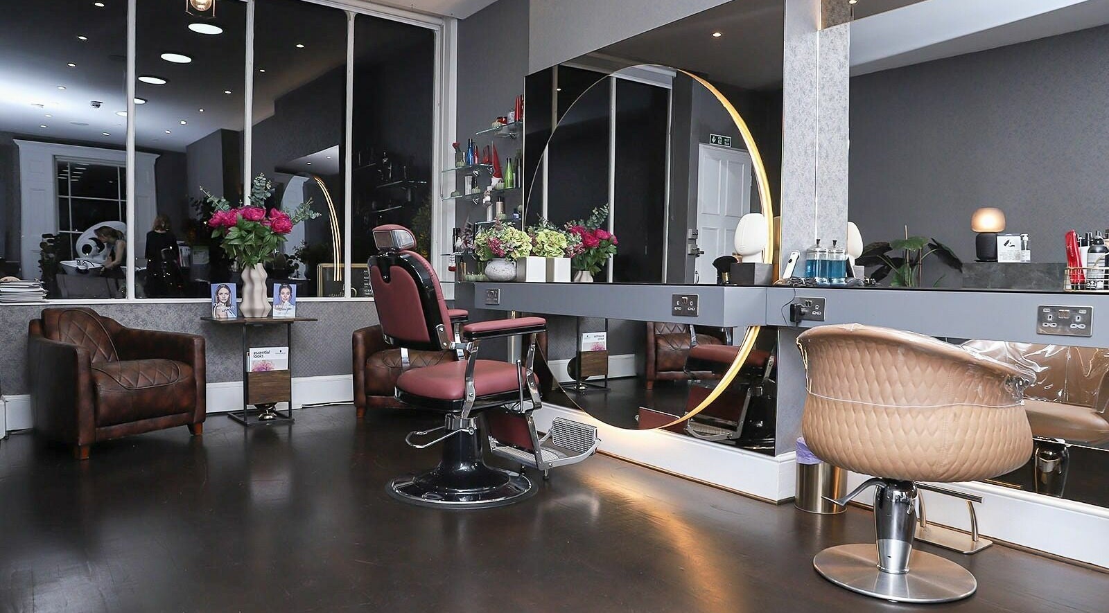 Modern salon interior at Studio 52 Hair and Beauty, London, England, GB, featuring elegant styling chairs and mirrors.