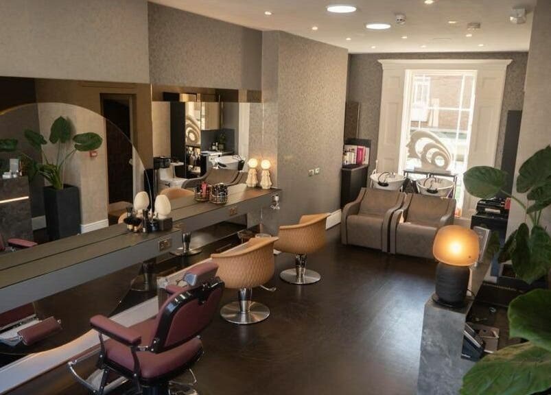 Chic interior of Studio 52 Hair and Beauty in London, England, GB, featuring sleek styling chairs and large mirrors.