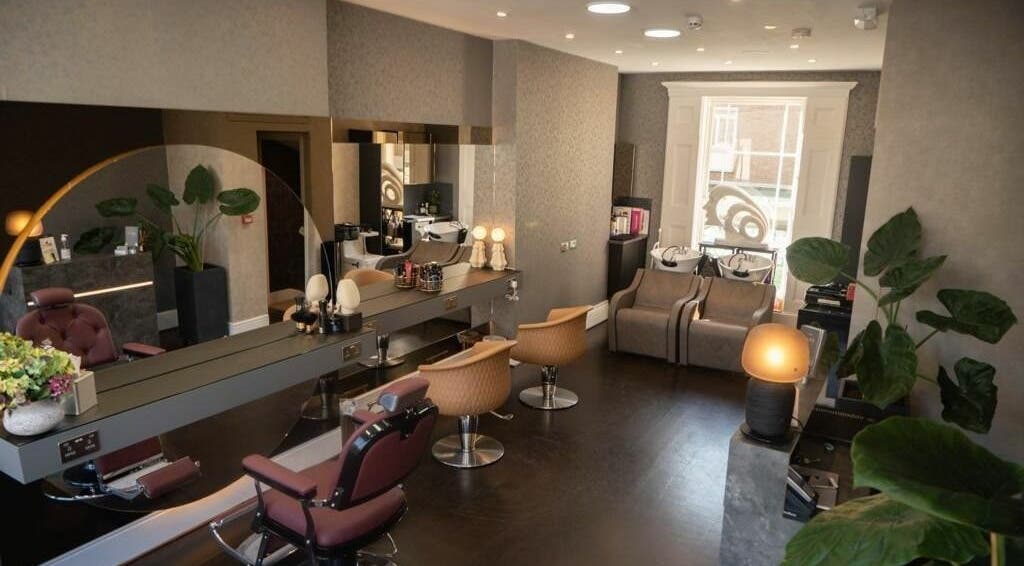 Chic interior of Studio 52 Hair and Beauty in London, England, GB, featuring sleek styling chairs and large mirrors.