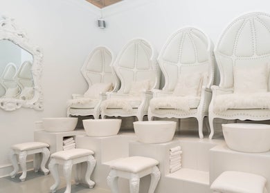 Luxurious pedicure seating at Prép Beauty Parlour, Vancouver, British Columbia, CA. Plush white chairs and ornate mirror.