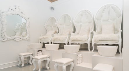 Luxurious pedicure seating at Prép Beauty Parlour, Vancouver, British Columbia, CA. Plush white chairs and ornate mirror.