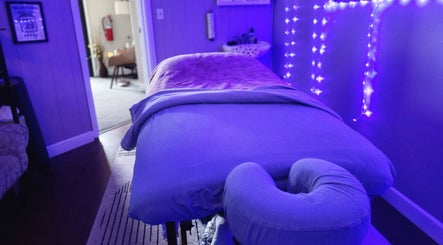 Massage table in a softly lit room at Braven at Relaxations in Alma, Michigan, US, creating a soothing ambiance.