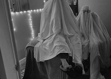 Two figures under sheets in a softly lit room at Braven at Relaxations, Alma, Michigan, US.