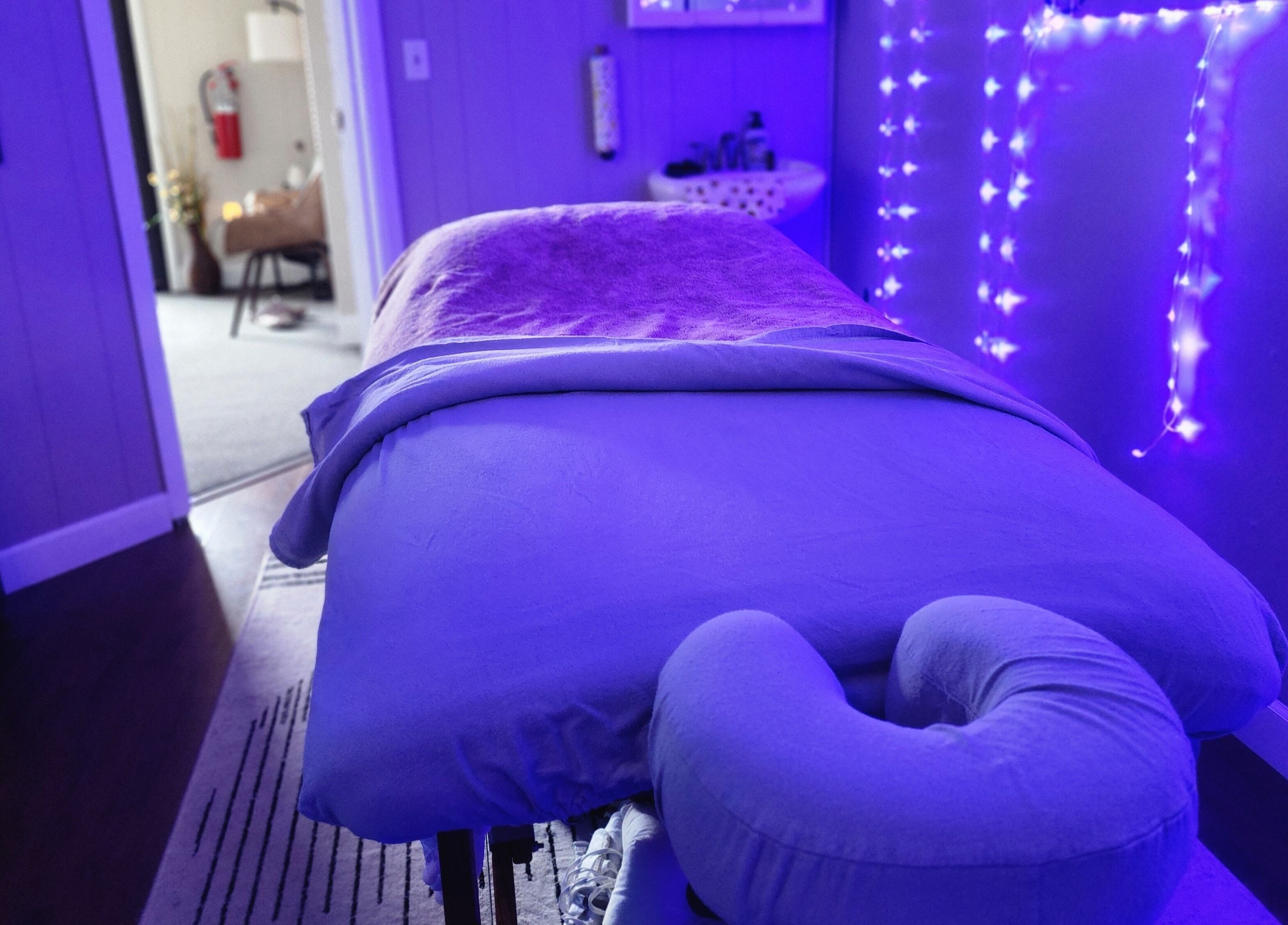 Tranquil massage room at Braven at Relaxations, Alma, Michigan, US, with calming blue lighting.