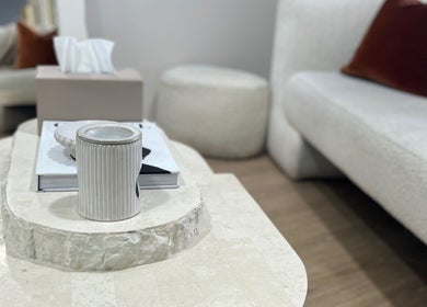 Cozy seating area at Facial Skin Specialist, Smithfield 2164, New South Wales, AU, featuring a stone table and sofas.