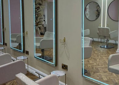 Elegant salon interior at House of GC Salon, Leslie, Scotland, GB, featuring illuminated mirrors and modern chairs.