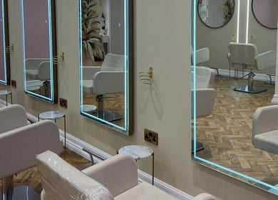 Elegant salon interior at House of GC Salon in Leslie, Scotland, GB, featuring stylish chairs and illuminated mirrors.