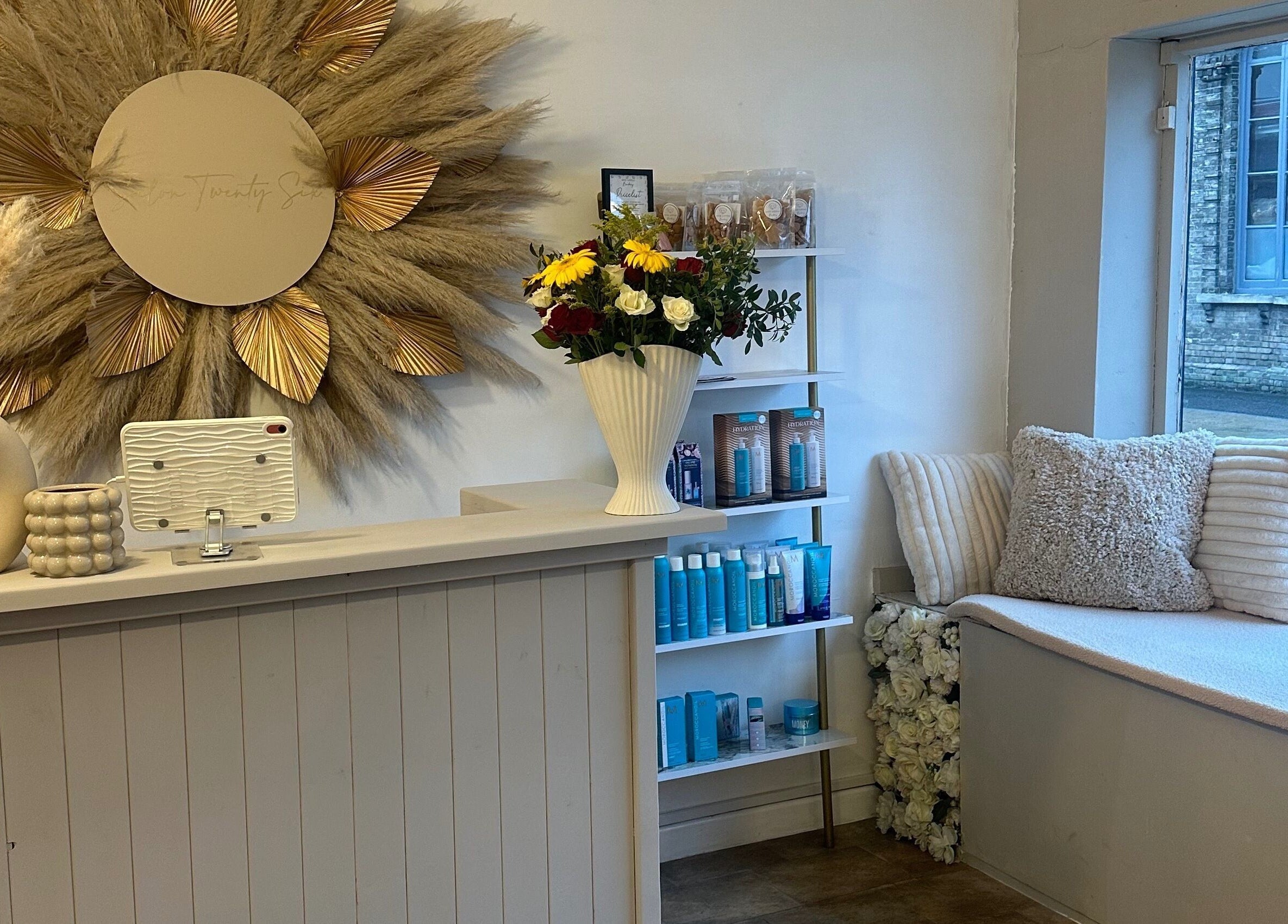Elegant lobby of Salon Twenty Six in Attleborough, England, GB with floral decor and cozy seating.