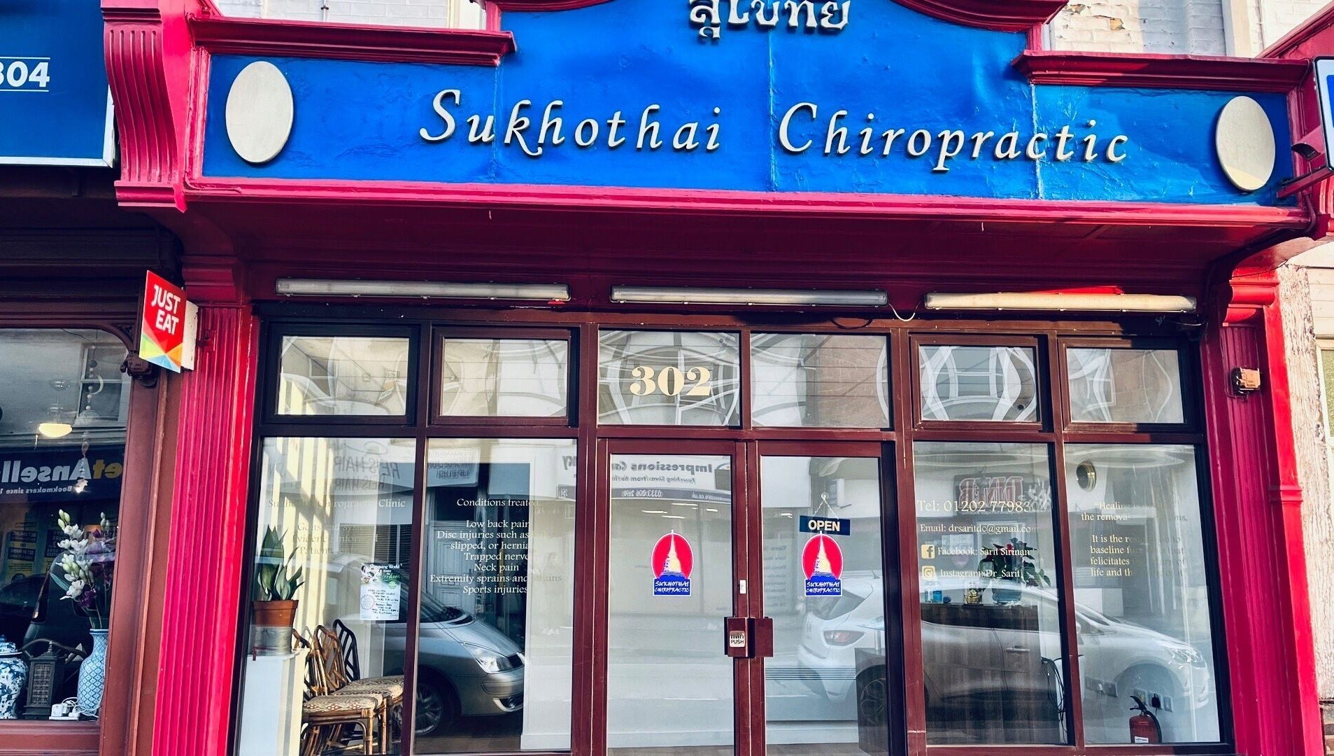 Exterior of Sukhothai Chiropractic Clinic in Bournemouth, England, GB with red facade and blue sign.