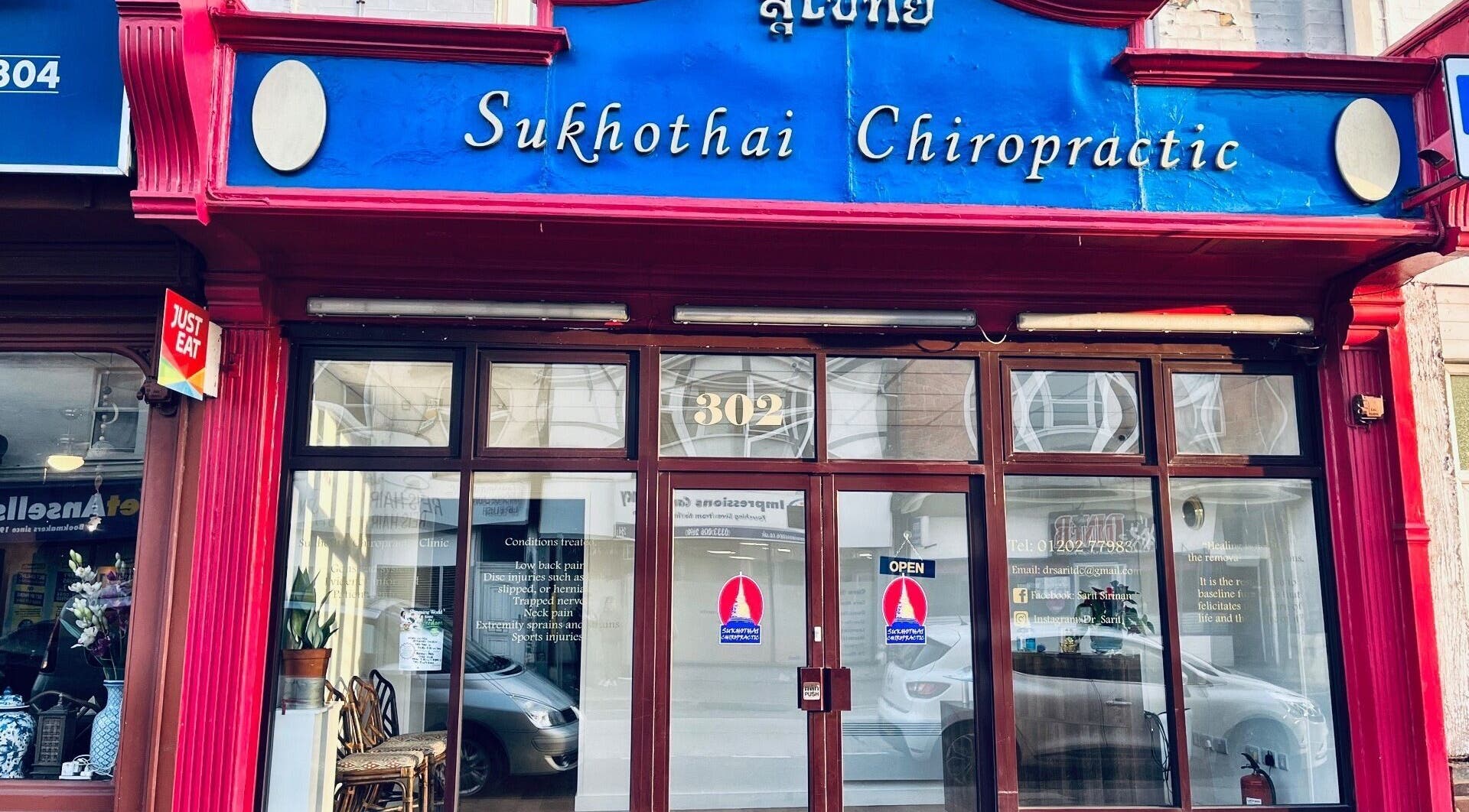 Exterior of Sukhothai Chiropractic Clinic in Bournemouth, England, GB with red facade and blue sign.