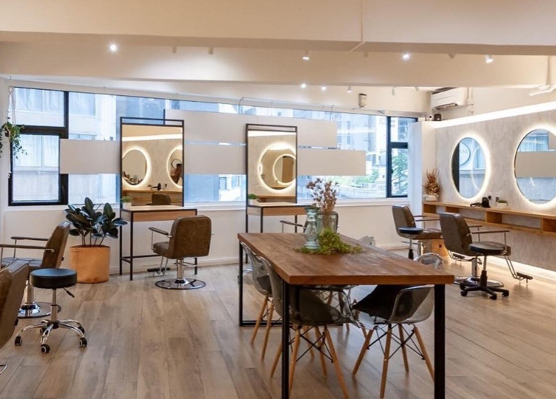 Modern and inviting interior of Sozo Hair Design, Hong Kong Island, showcasing salon chairs and mirrors.