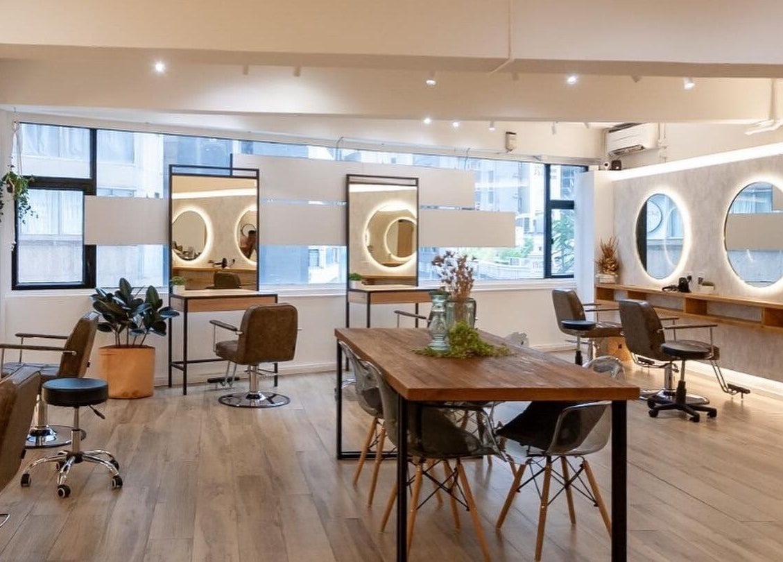 Modern and inviting interior of Sozo Hair Design, Hong Kong Island, showcasing salon chairs and mirrors.
