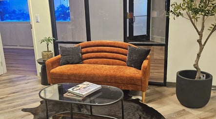 Elegant orange sofa at The Fairy Hair Godmother, High Point, North Carolina, US enhances salon's welcoming ambiance.
