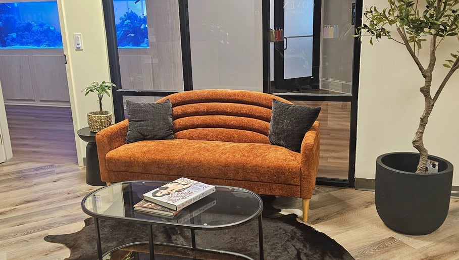 Inviting orange sofa at The Fairy Hair Godmother®️, High Point, North Carolina, US. Perfect relaxation spot.