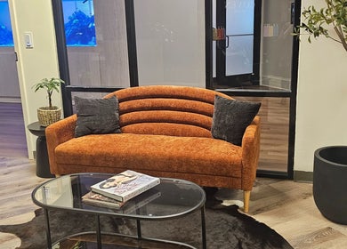 Inviting orange sofa at The Fairy Hair Godmother®️, High Point, North Carolina, US. Perfect relaxation spot.
