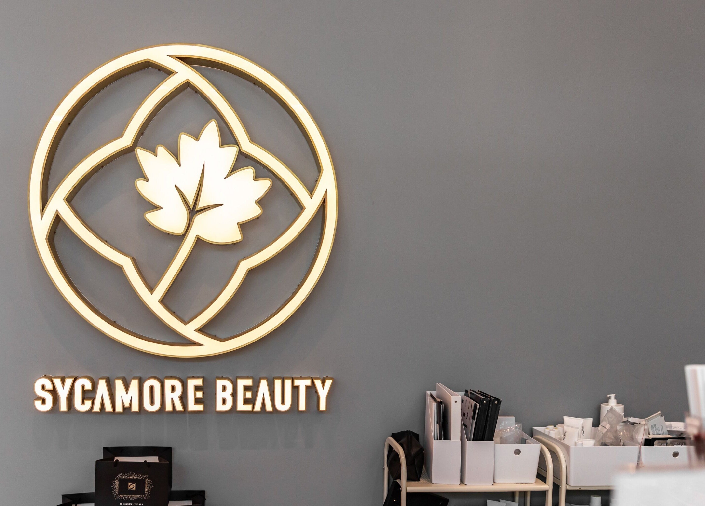Sycamore Medi Spa - Civic logo wall in Canberra, Australian Capital Territory, AU with beauty products.