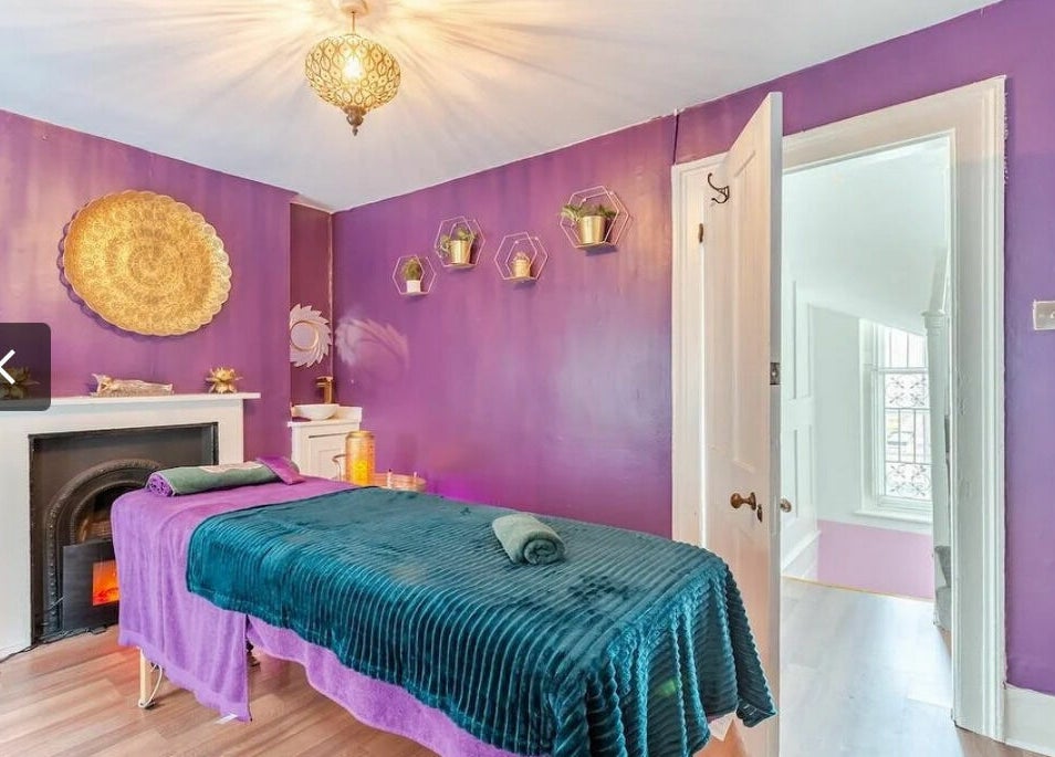 Relaxing violet-hued massage room at Aura Organics Spa - Greenwich, London, England, GB showcasing serene ambiance.