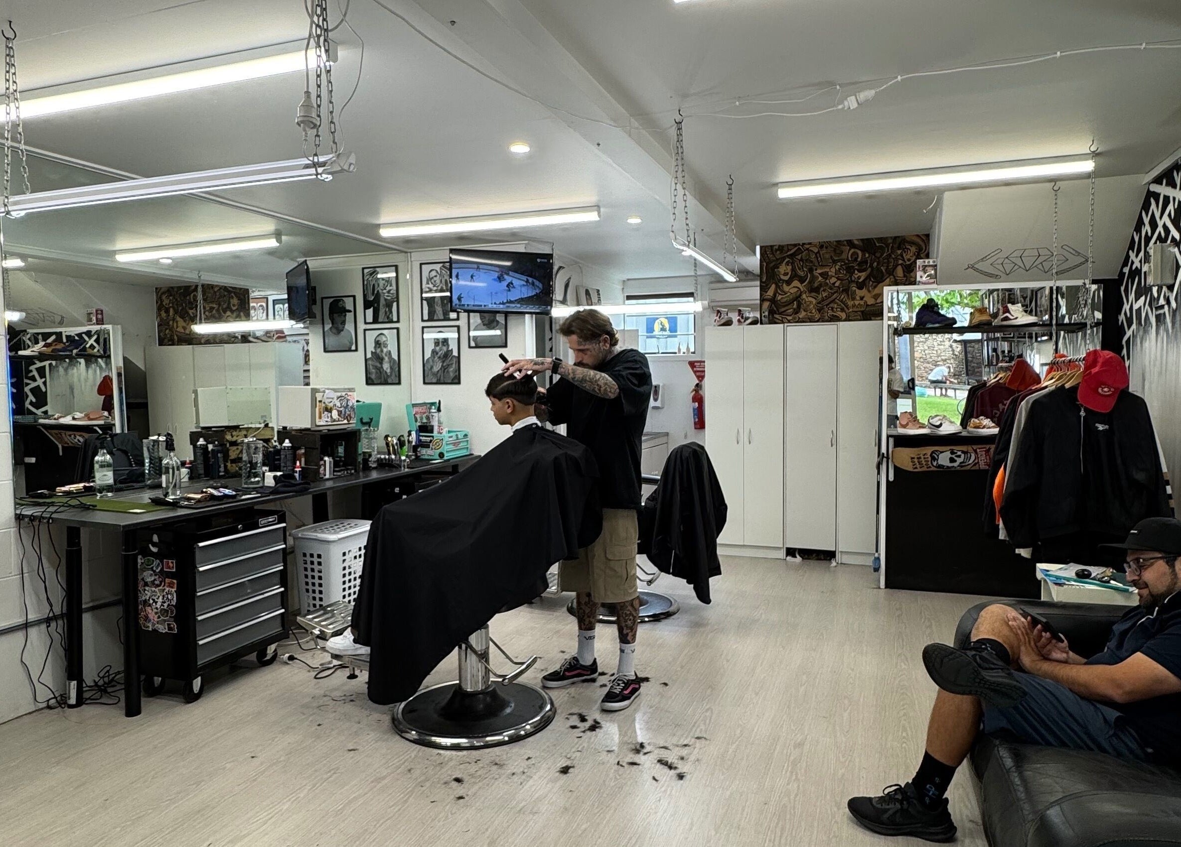 Modern interior of Three Diamonds Barbershop in Cromwell, Otago, NZ, showing hair styling and vibrant decor.