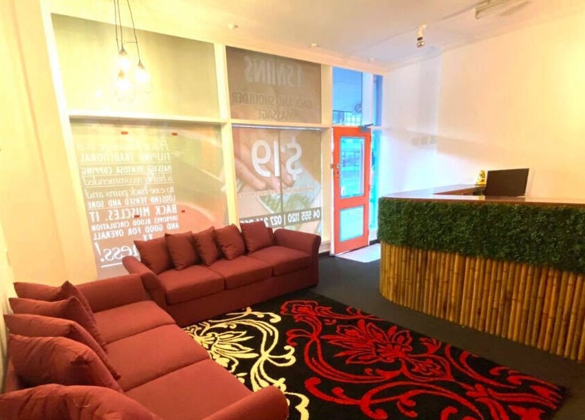Cozy reception area at Bamboo Spa Lower Hutt Wellington showcasing a red sofa and bamboo-themed decor in Lower Hutt, Wellington, NZ.
