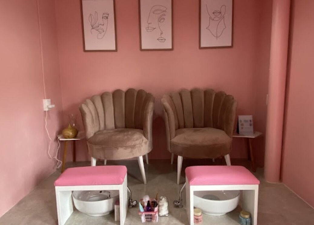 Zona de manicura rosa en SPA BY DAN, Ciudad De México, MX, con sillas mullidas y arte minimalista.