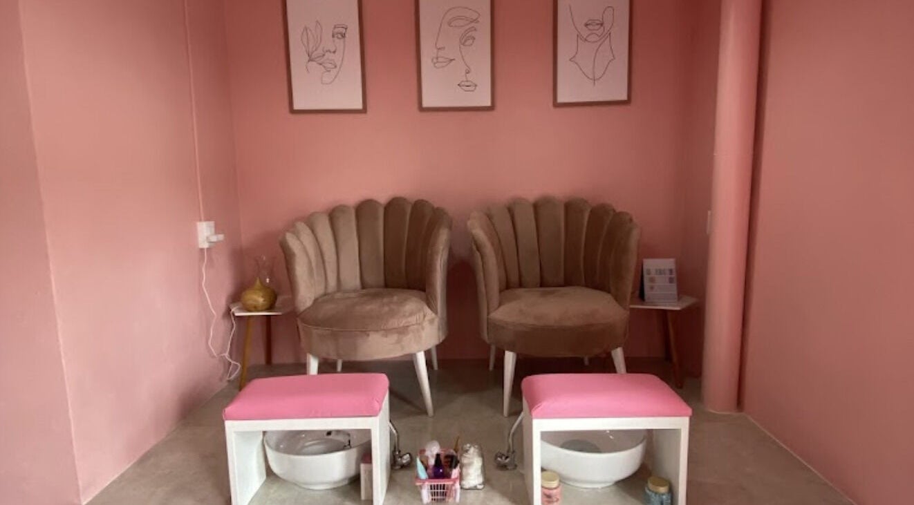 Zona de manicura rosa en SPA BY DAN, Ciudad De México, MX, con sillas mullidas y arte minimalista.
