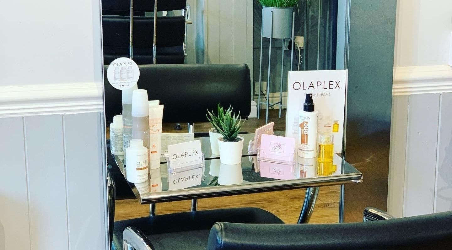 Olaplex products showcased on a sleek table at JB Hair in Rode Heath, England, GB. Modern salon interior.