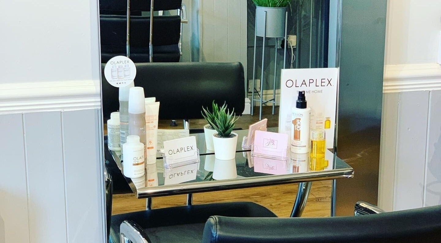 Olaplex products showcased on a sleek table at JB Hair in Rode Heath, England, GB. Modern salon interior.
