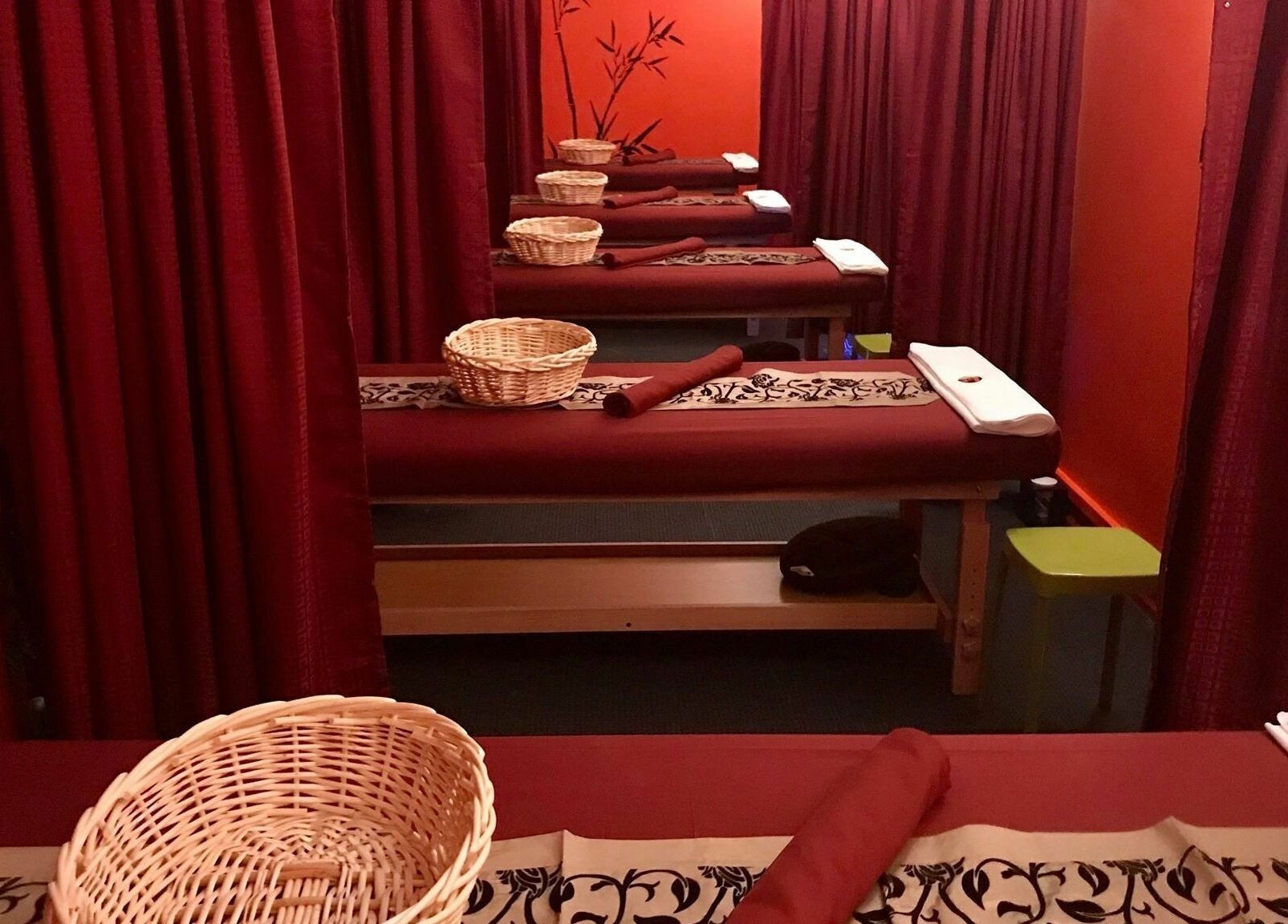 Relaxing massage tables at Bamboo Spa Hamilton, Hamilton, Waikato, NZ, with red curtains and calm ambiance.