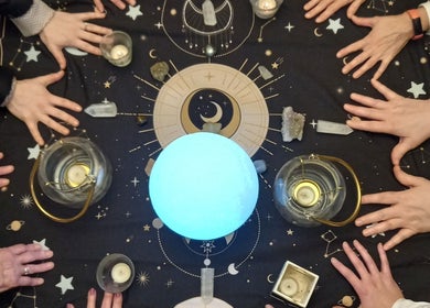 Hands form a circle around glowing sphere at Giovanna Baistrocchi's session in Craigavon, Northern Ireland, GB.