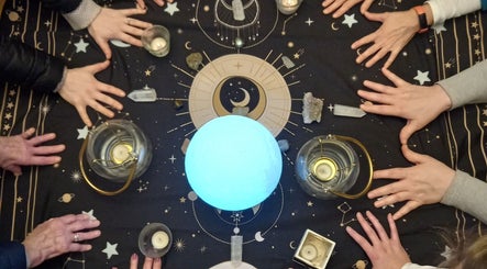 Hands form a circle around glowing sphere at Giovanna Baistrocchi's session in Craigavon, Northern Ireland, GB.
