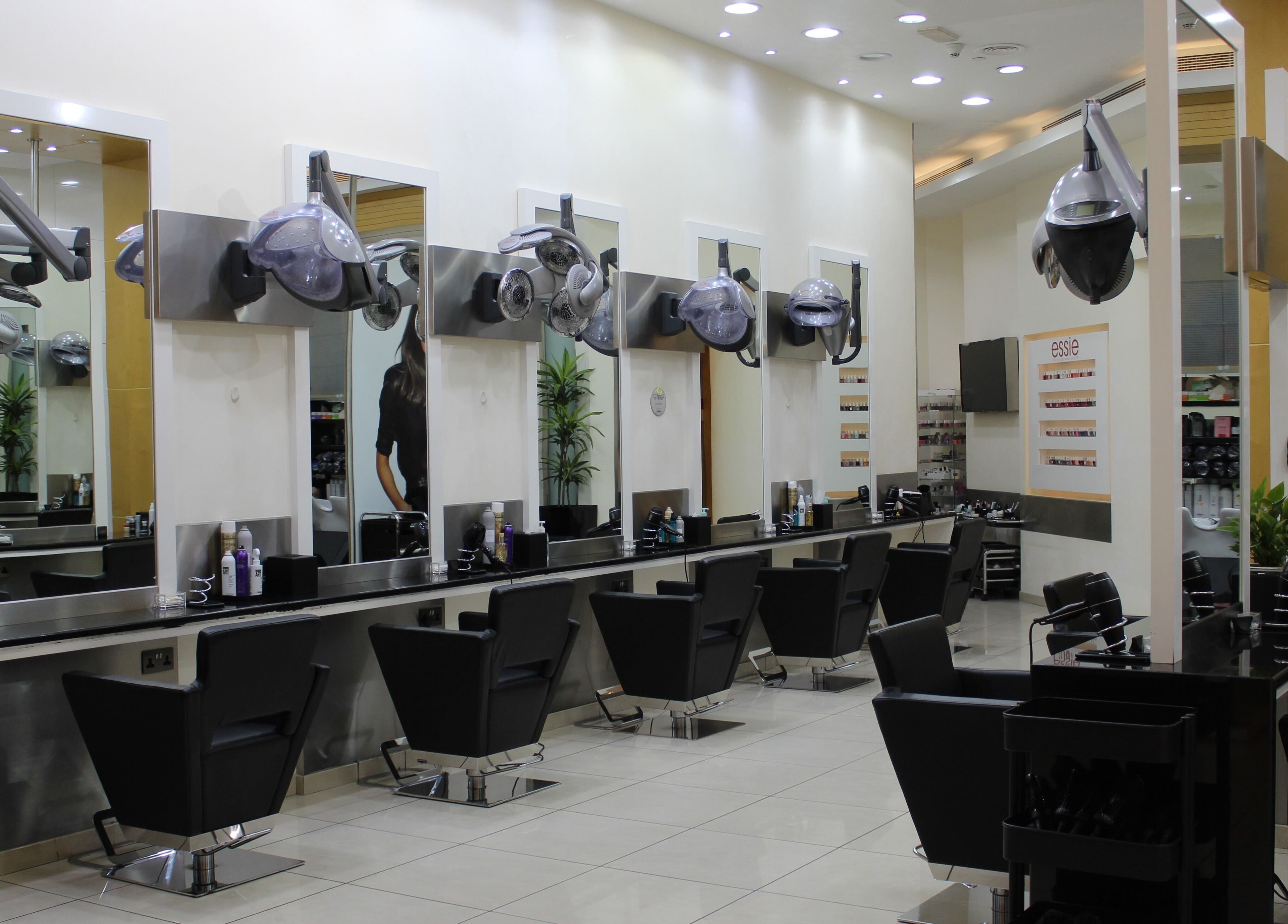 Modern hair salon interior at Amro - The Collection Mall - Abu Dhabi, featuring stylish chairs and mirrors.