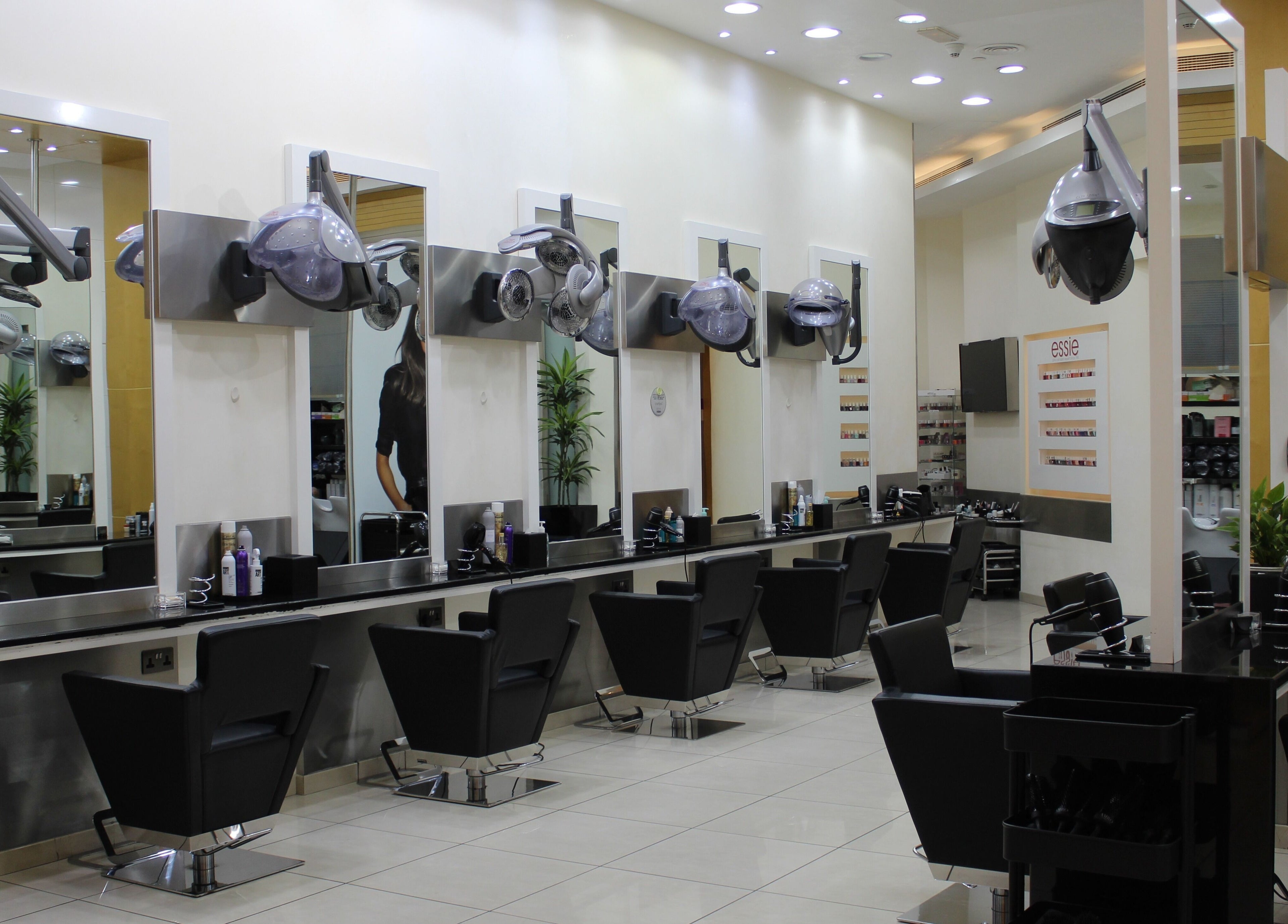 Modern hair salon interior at Amro - The Collection Mall - Abu Dhabi, featuring stylish chairs and mirrors.