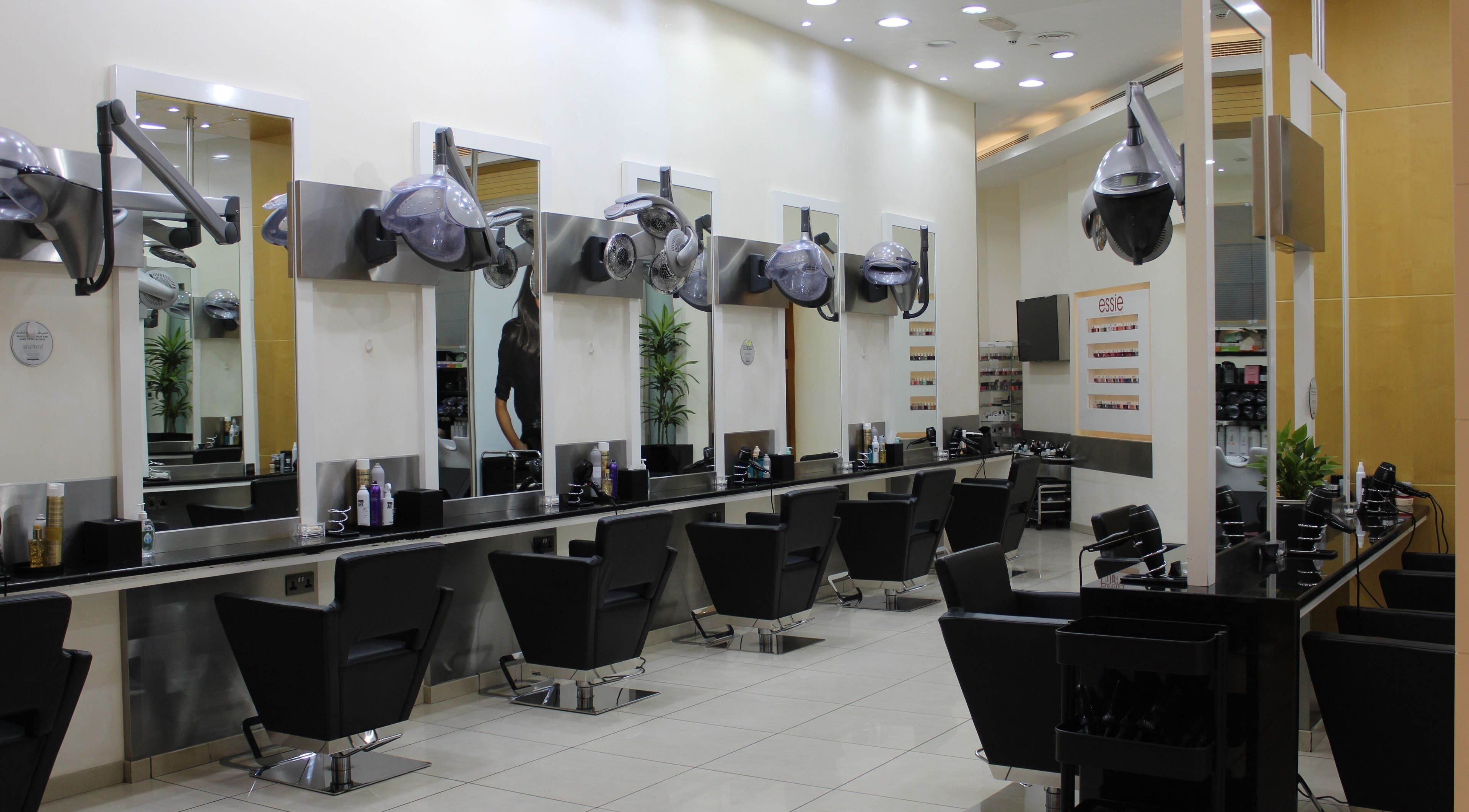 Modern hair salon interior at Amro - The Collection Mall - Abu Dhabi, featuring stylish chairs and mirrors.