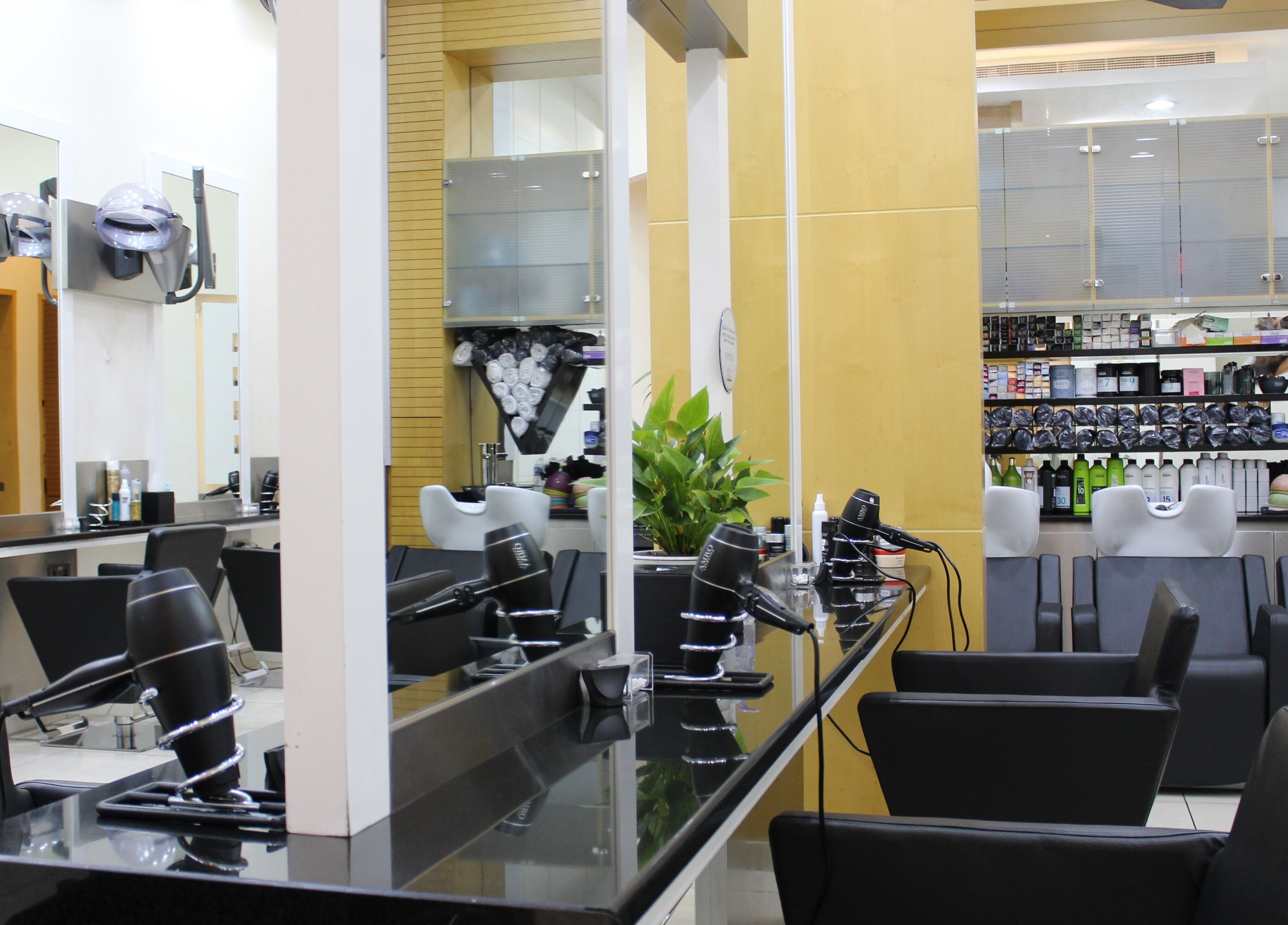 Modern hair salon at Amro - The Collection Mall - Abu Dhabi, featuring sleek black chairs and styling stations.