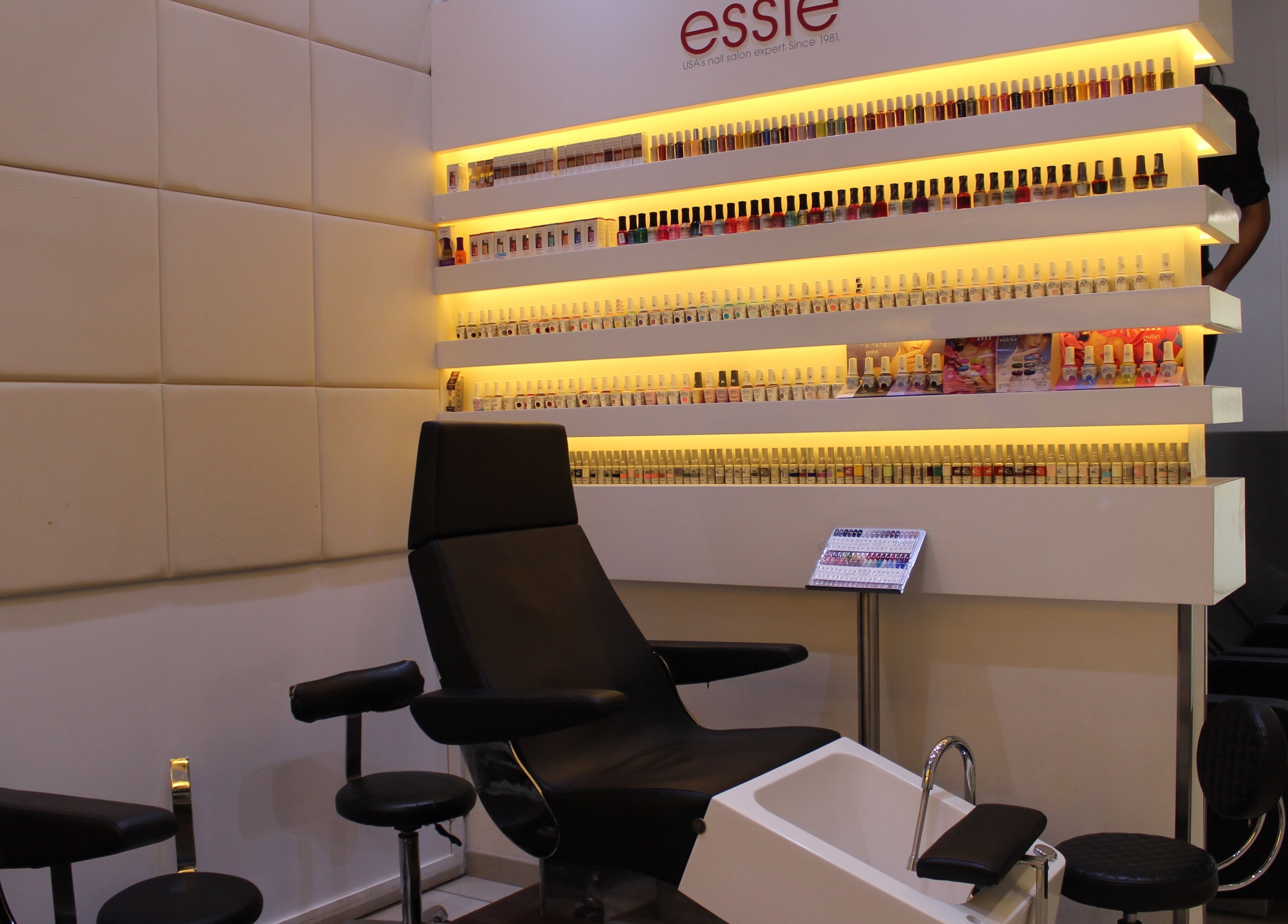 Nail salon area at Amro - St.Regis Saadiyat Island - Abu Dhabi, featuring stylish chairs and nail polish display.