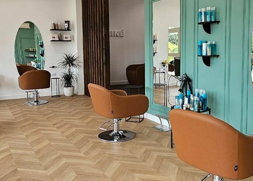 Interno moderno di Salone Ninè a Pomezia, Lazio, IT con poltrone marroni e specchi verdi.