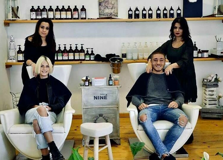 Interno del Salone Ninè a Pomezia, Lazio, IT con due clienti e il personale sorridente.