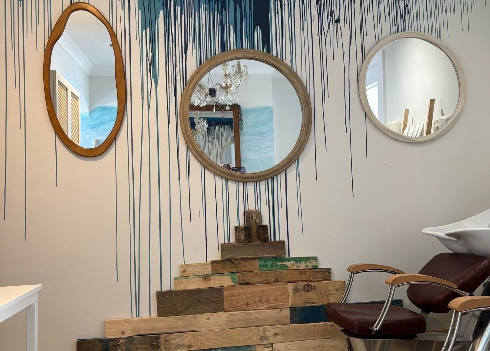 Unique mirror wall design at The Curl Girl Devon, Braunton, England, GB, with a modern salon chair and sink.