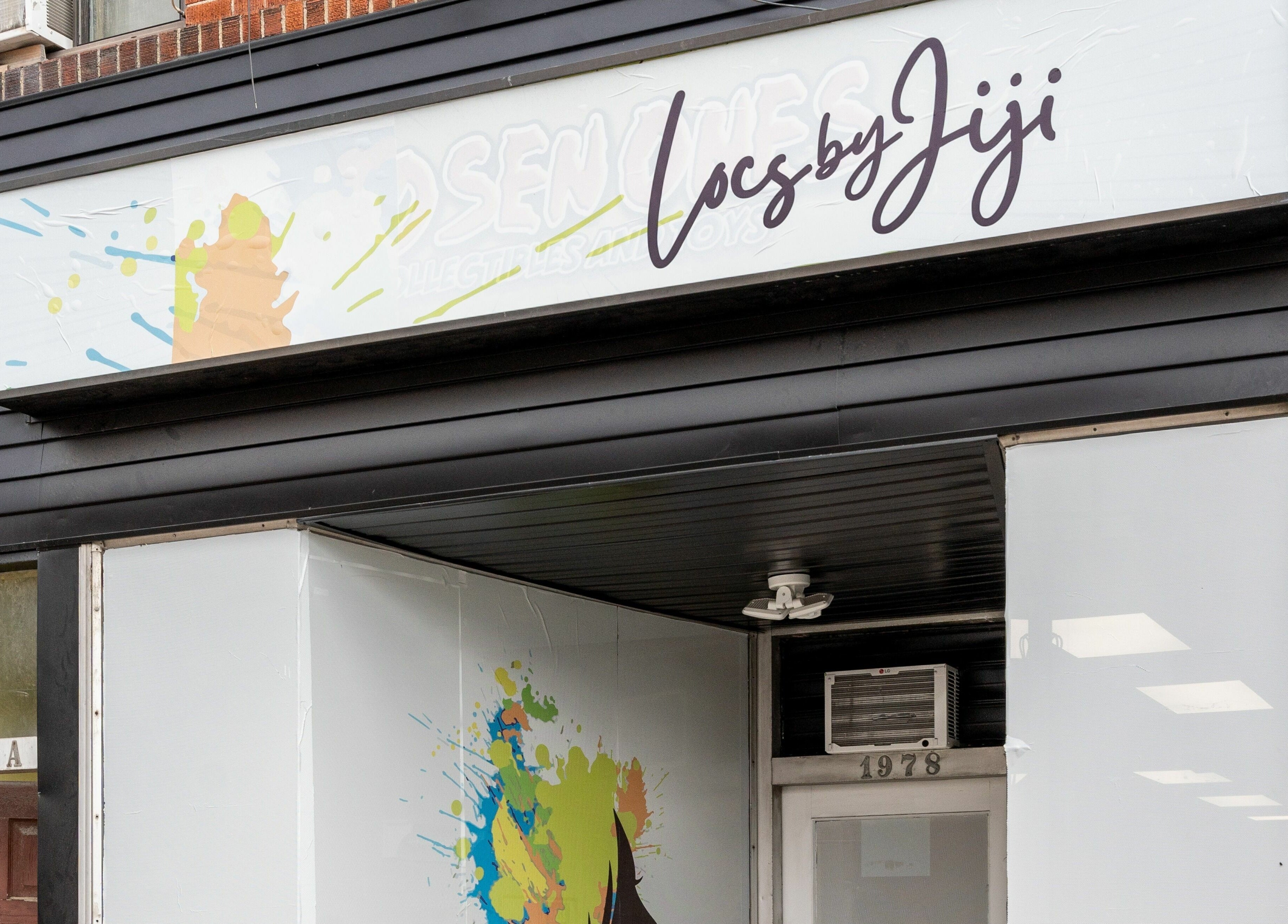 Exterior of Locs by Jiji salon in Toronto, Ontario, CA, showcasing a stylish black facade.