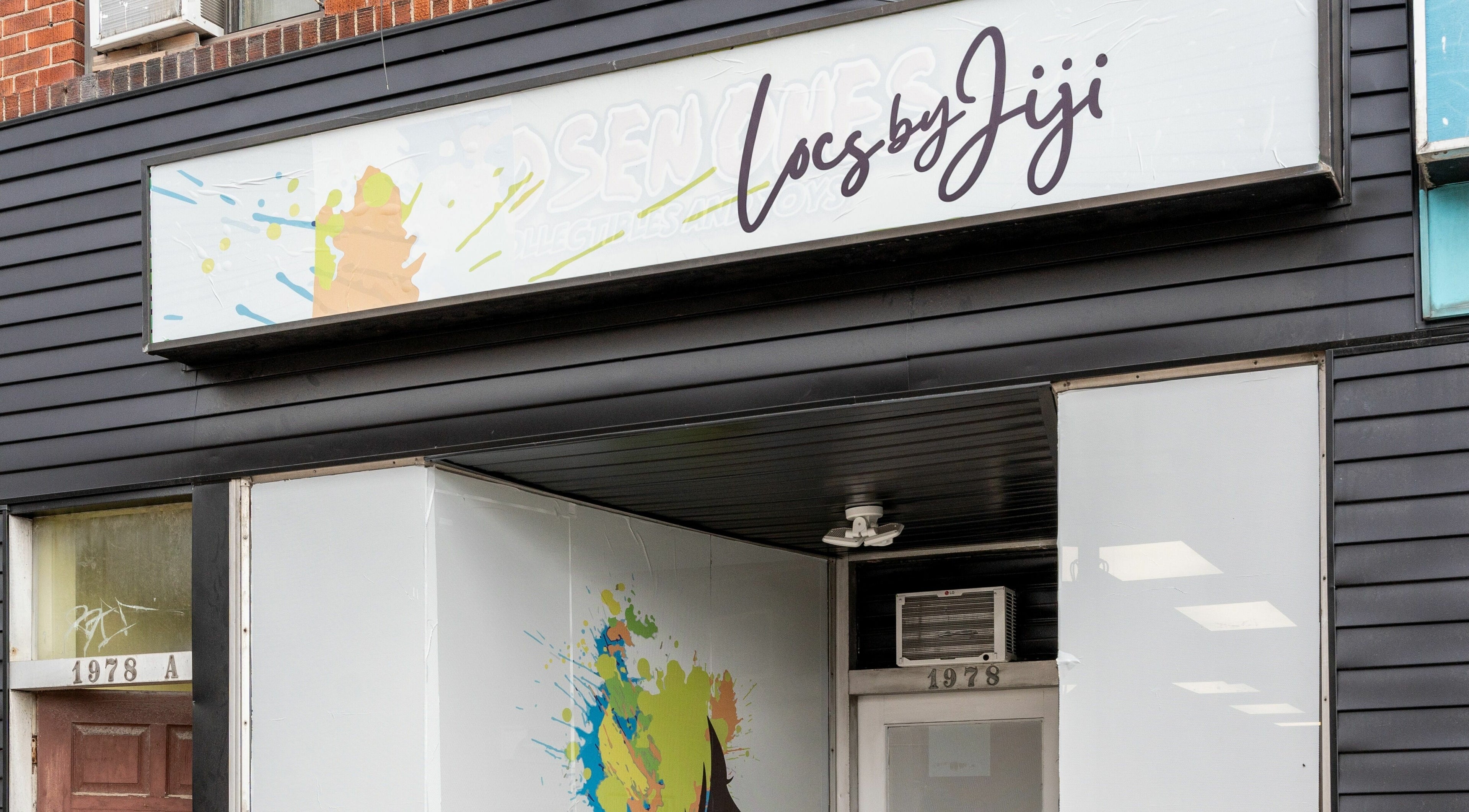 Exterior of Locs by Jiji salon in Toronto, Ontario, CA, showcasing a stylish black facade.