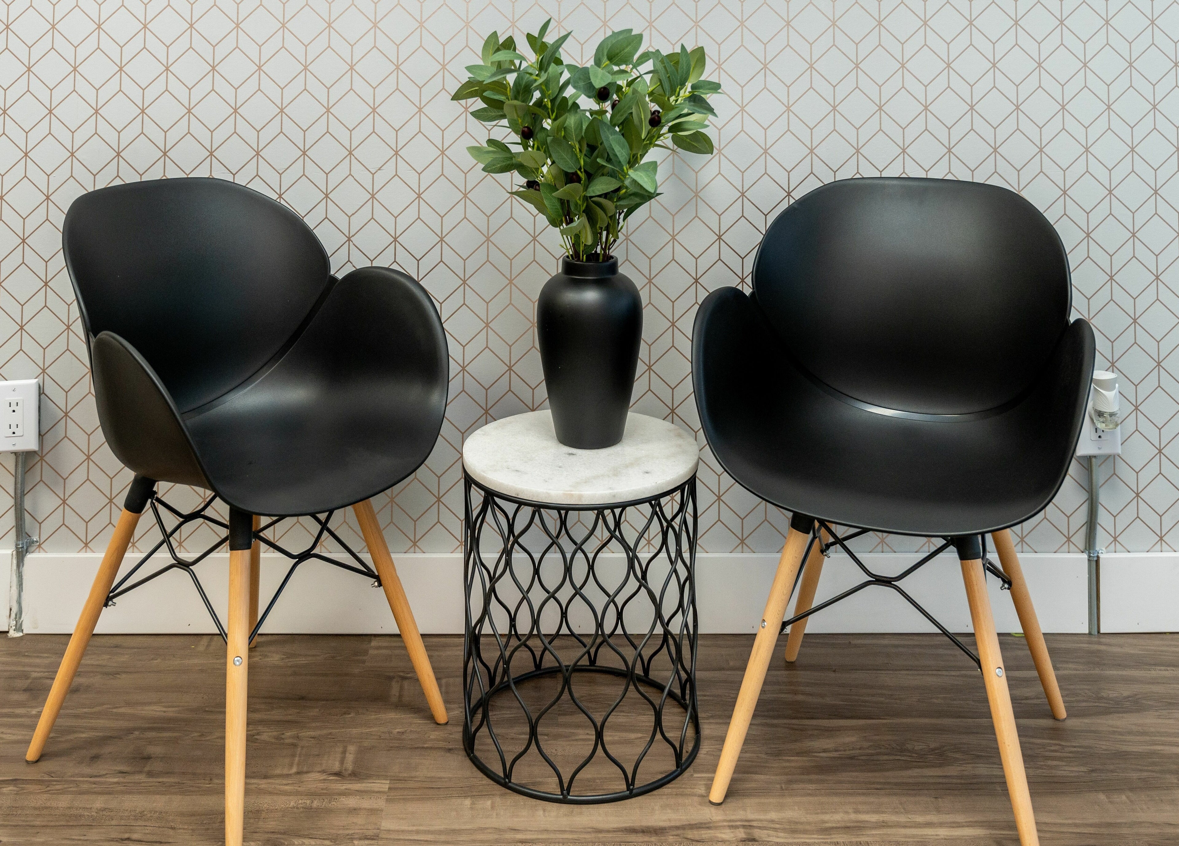 Chic black chairs and a vase on a table at Locs by Jiji, Toronto, Ontario, CA.
