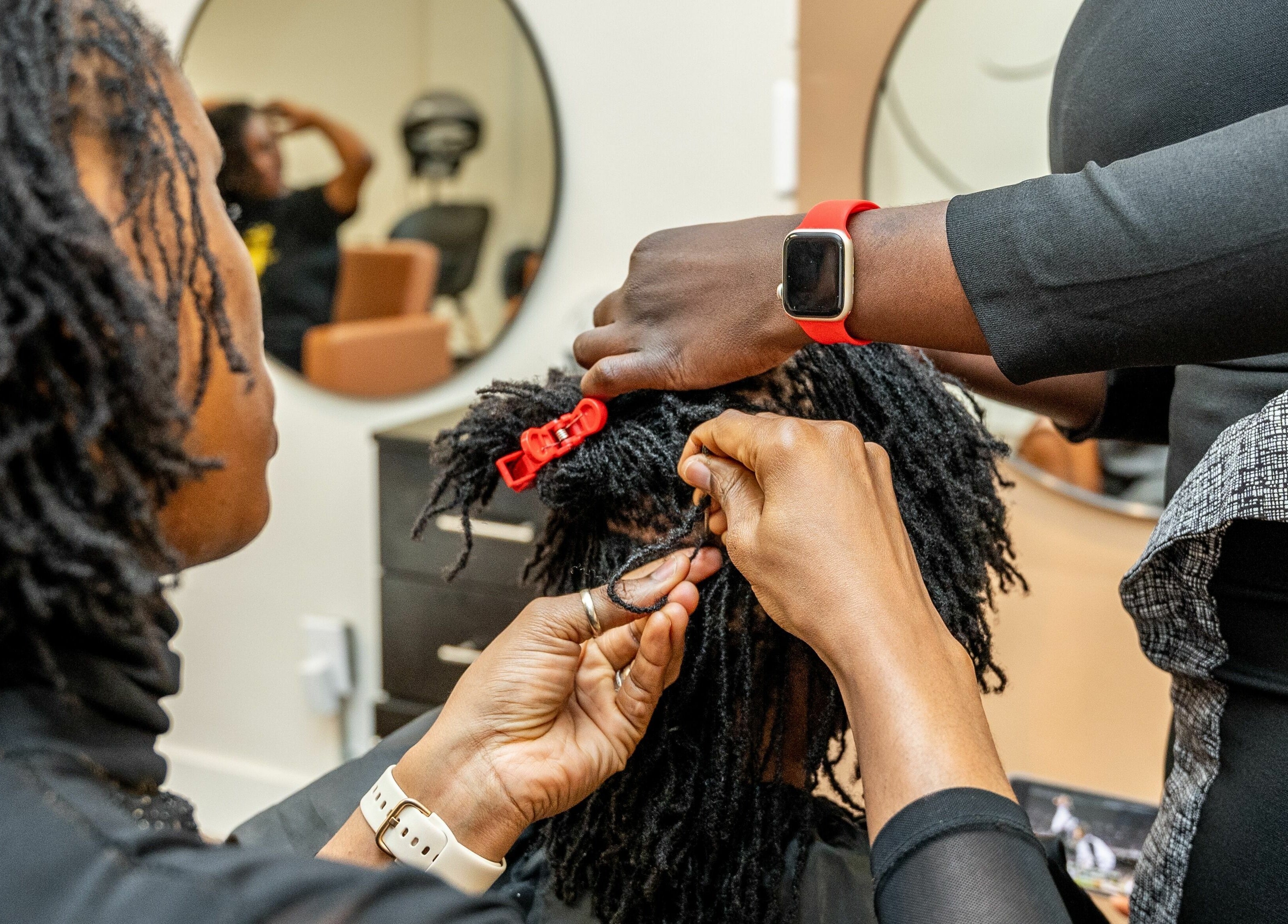 Stylist perfects locs at Locs by Jiji in Toronto, Ontario, CA, showcasing expert hair techniques.