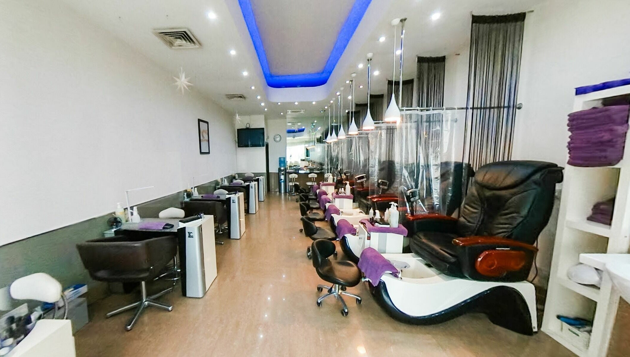 Spacious interior of Princess Nails Wimbledon in London, England, GB with luxurious massage chairs and nail stations.