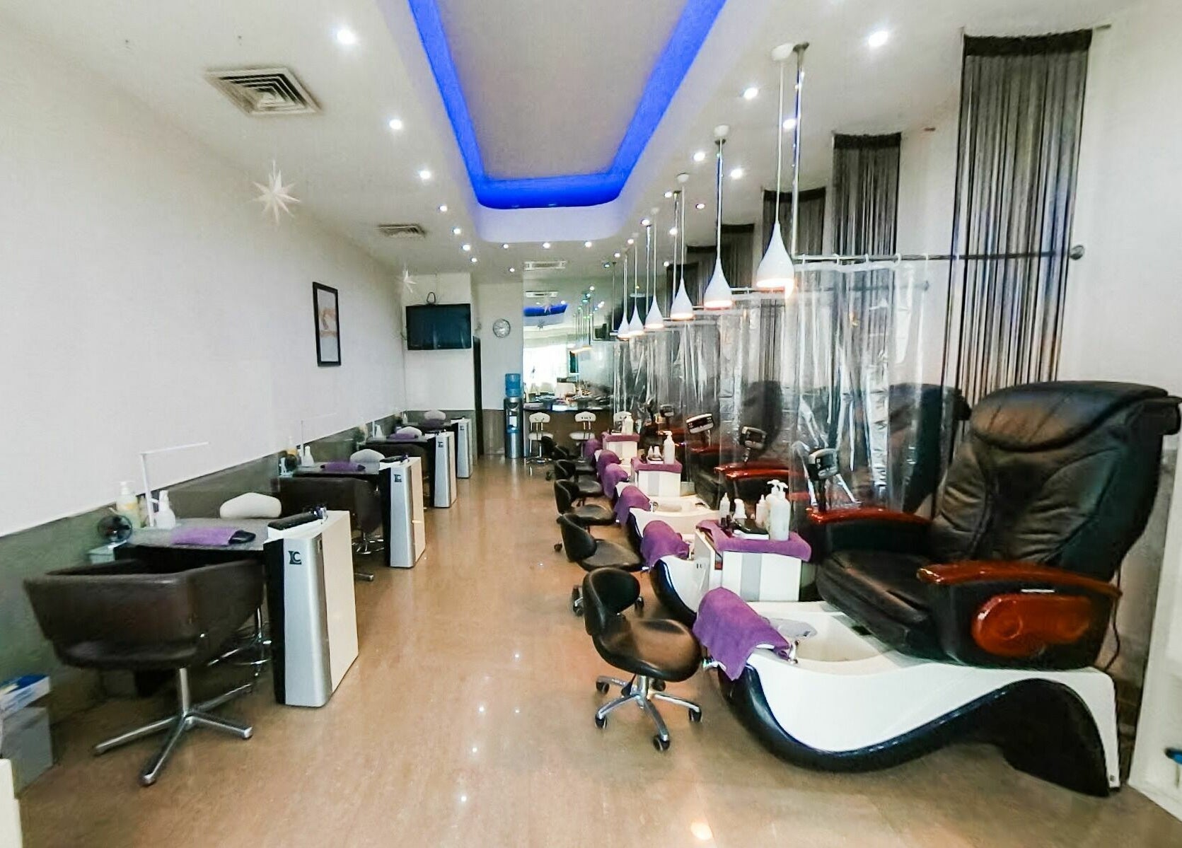 Spacious interior of Princess Nails Wimbledon in London, England, GB with luxurious massage chairs and nail stations.