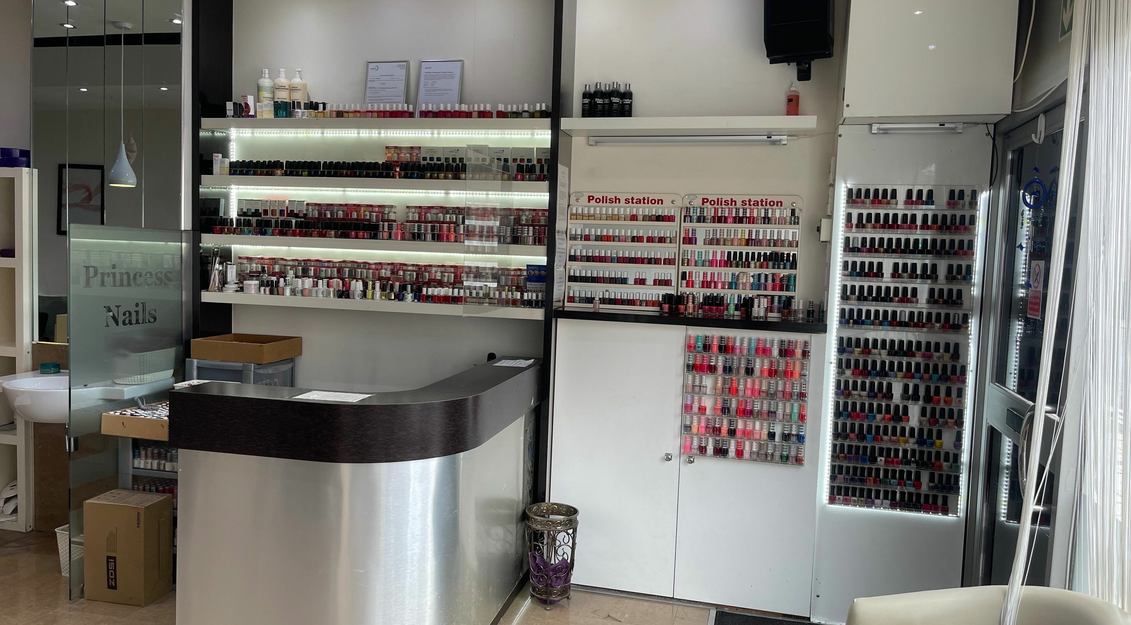 Interior of Princess Nails Wimbledon, showcasing a polished counter and extensive nail polish collection in London, England, GB.
