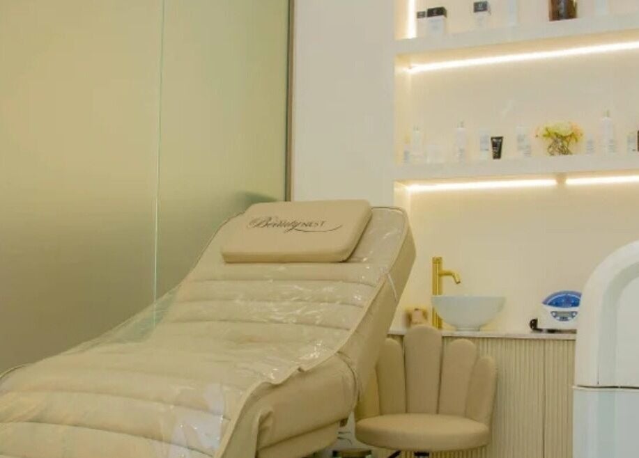 Cozy spa lounge with beige chair at The Beauty Nest, London, England, GB, offering relaxing treatments.