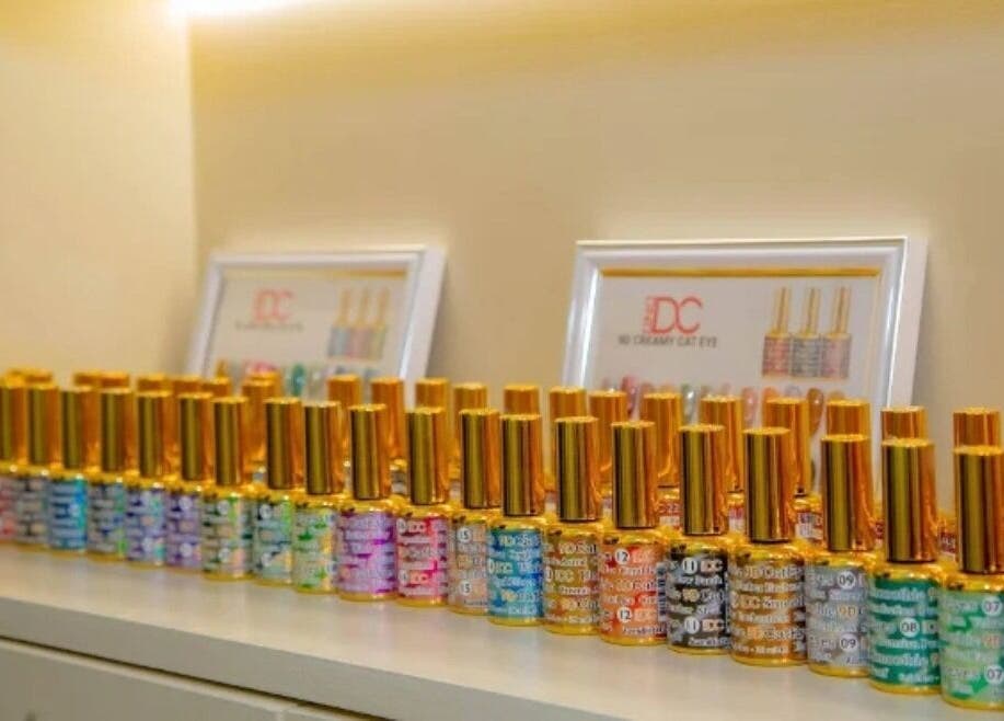 Vibrant nail polish collection at The Beauty Nest, London, England, GB with gold caps on display.