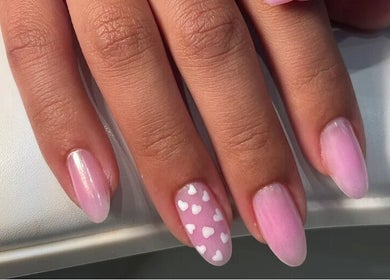 Pink nails with white heart design at Morya Beauty Centre, Sharjah, Sharjah, AE.