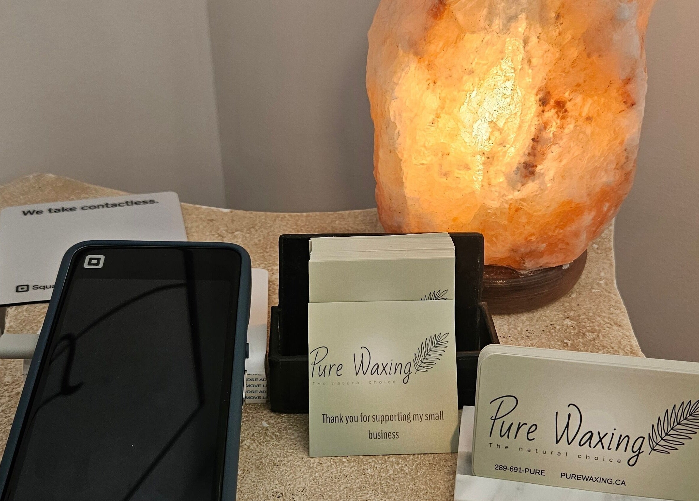 Pure Waxing business cards beside a glowing lamp; Quinte West, Ontario, CA.