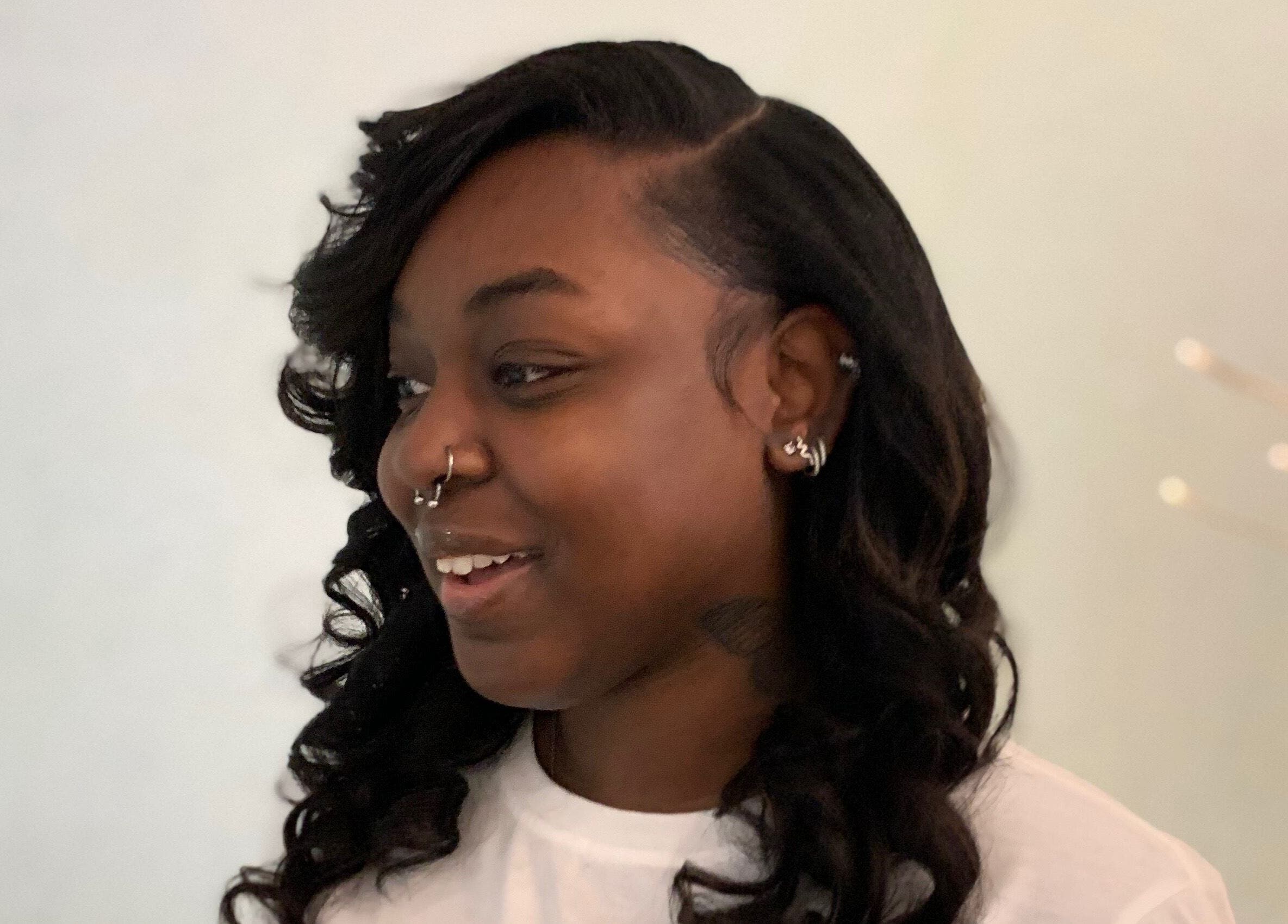 Customer smiling with styled hair at The Root Refresh Salon, Minneapolis, Minnesota, US.